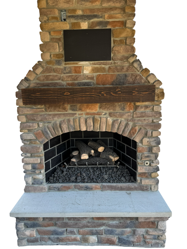 Stone outdoor fireplace with a wooden mantel and firewood inside.